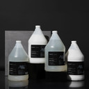 Amenie Sicilian Tangerine gallon-size shampoo, conditioner, body wash, and lotion set against a dark background for a premium look