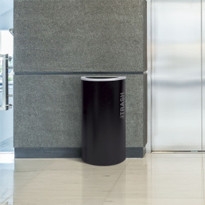 Ex-Cell Kaleidoscope trash can placed against wall in hotel hallway or corridor