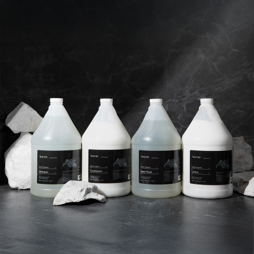 Full case of Amenie Sicilian Tangerine Shampoo gallon bottles arranged on black background