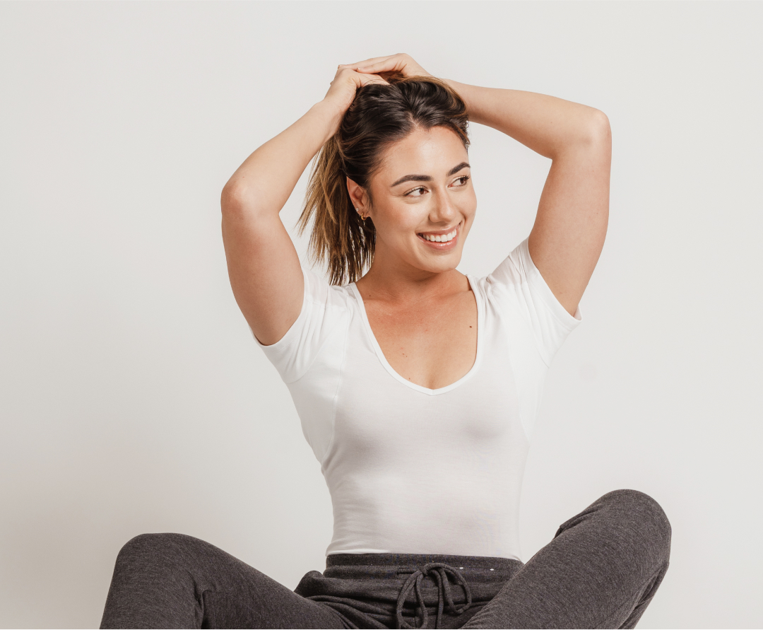 Woman wearing Thompson Tee White Slim Fit Women’s Sweat Proof Undershirt and showing the underarm pads