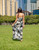 Model wearing Napua Collection Ruffle Maxi Dress - Abstract Monstera: Black Pattern (Back)