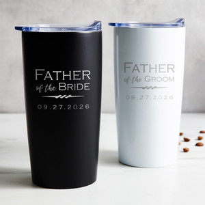 Personalized Father of the Bride or Groom stainless steel coffee tumbler in black or white laser engraved with wedding title and wedding date, displayed on table.