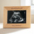 Custom light wood frame that holds an ultrasound photo engraved with "love at first sight" on top and custom text at the bottom