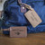 Logo Engraved Vegan Leatherette Luggage Tags for Bulk Orders shown attached to a duffel bag
