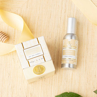 Flat lay of oatmilk honey room spray with soft beige packaging and coordinating bath products
