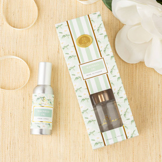 Flat lay of magnolia fig diffuser with mint and green botanical design and fragrance oil bottle