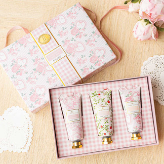 Flat lay of sweetheart blooms hand cream trio with pastel floral designs and gift-ready box