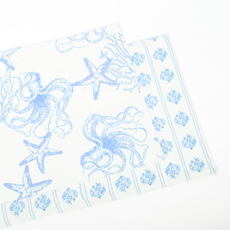 Reversible placemat with blue sea-inspired toile design and coordinating striped reverse side (top view)