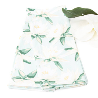 Magnolia mint kitchen towel styled with magnolia flowers showing green botanical design