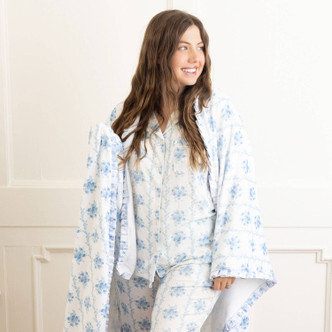 Woman wrapped in blue rose floral throw blanket showing cozy drape and relaxed fit