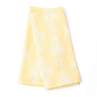Folded yellow kitchen towel with gold damask-inspired pattern (top view)