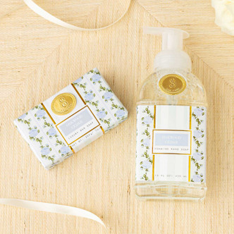 Flat lay of oakwood cedar bar soap and packaging with mint and blue floral design and gold accents