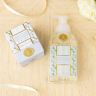 Flat lay of oakwood cedar foaming hand soap with mint and blue floral design and gold accents