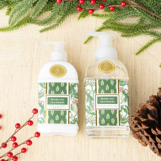 Woodland Cranberry hand & body lotion pump bottle with a green holly and berry print label (alternate angle)