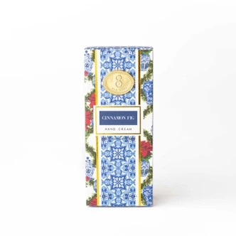 Cinnamon Fig hand cream box and tube in a blue-and-white tile print with poinsettia accents (alternate angle)