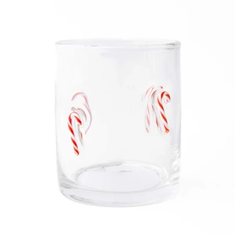 Clear drinking glass with candy cane bead icons, filled with a festive holiday drink (alternate angle)