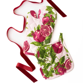 Pomegranate Grove print oven mitt and pot holder set styled with fresh pomegranates (alternate angle)