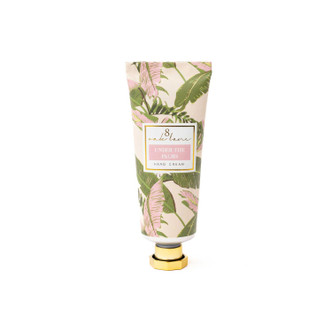 Under the Palms travel hand cream tube with a pink and green palm frond print