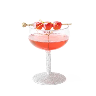 Glass Christmas ornament shaped like a glittered cocktail coupe with a red drink and cherry garnish (alternate angle)
