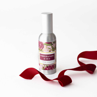 Pomegranate & Oud room spray bottle with a botanical label and red ribbon