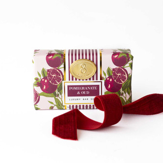 Wrapped bar soap with a pink pomegranate print and red ribbon