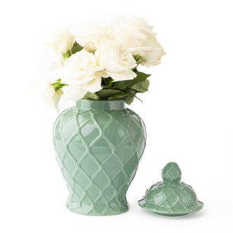 Large glossy sage-green ginger jar with raised geometric texture, styled with white roses