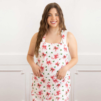 Woman wearing the Holly Jolly Bows cotton apron with a red and pink holiday print