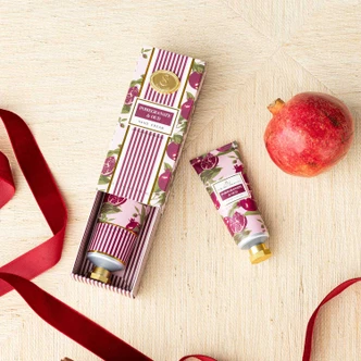 Pomegranate & Oud travel hand cream tube in a pink pomegranate print (alternate angle)