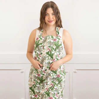 Woman wearing the Woodland Berry cotton apron with a green pine and red berry print