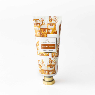 Gingerbread travel hand cream tube in a tan and gold gingerbread-house print