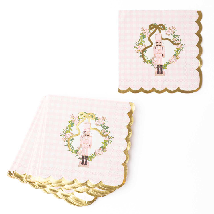 Pink gingham paper beverage napkin with a nutcracker in a floral wreath and gold scalloped edge