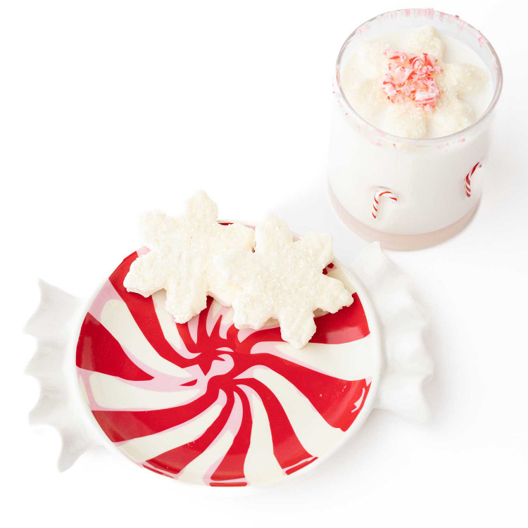 Ceramic dessert plate shaped like a red and white swirled peppermint candy, holding snowflake cookies