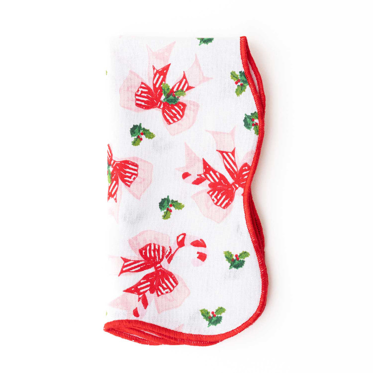 Holly Jolly Bows scalloped dinner napkin with a red trim and pink and red bow print