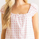 Close-up of pink gingham cotton pajama top with strawberry bud print and ruffle neckline detail