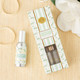 Flat lay of magnolia fig room spray with mint packaging and soft green botanical design