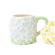 Hydrangea print mug styled with flowers, showing soft green botanical design (lifestyle view)