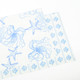 Reversible placemat with blue sea-inspired toile design and coordinating striped reverse side (top view)