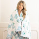 8 Oak Lane hydrangea ribbons luxe throw blanket 56 x 60 inches with blue floral print and pink ribbon detail (lifestyle view)