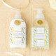 Close-up of oakwood cedar hand and body lotion bottle with mint and blue floral design and gold accents