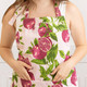 Woman wearing the Pomegranate Grove cotton kitchen apron with a pink pomegranate print (alternate angle)