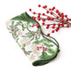 Folded cotton dinner napkin with a woodland berry and holly print and a scalloped green edge (alternate angle)
