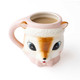 Ceramic coffee mug shaped like a pink reindeer face wearing a Santa hat and bowtie