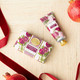 Wrapped bar soap with a pink pomegranate print and red ribbon (alternate angle)