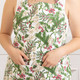 Woman wearing the Woodland Berry cotton apron with a green pine and red berry print (alternate angle)