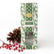 Woodland Cranberry reed diffuser with reed sticks in a holly and greenery print box (styled detail view)