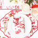 Santa Toile reversible scalloped placemat with a red village toile print and red striped reverse side (close-up view)