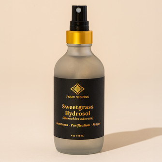 Sweetgrass hydrosol in glass spray bottle on beige background