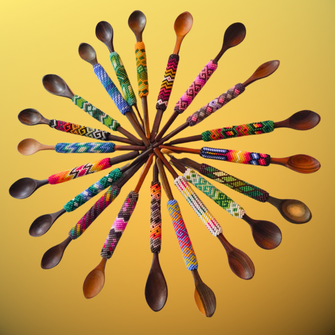 Beaded medicine spoons arranged in circle on yellow background