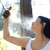 Person holding Munay healing lotion and spraying toward face