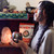Woman holding mug of ceremonial cacao with salt lamp in background